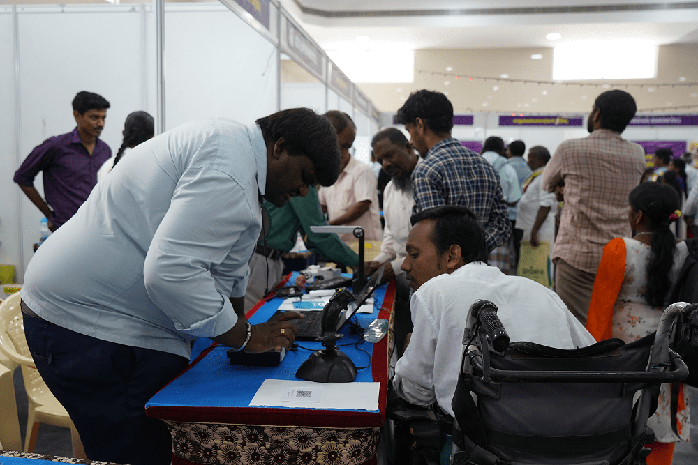 Individuals with disabilities participating in a job fair, engaging with technology and employment opportunities